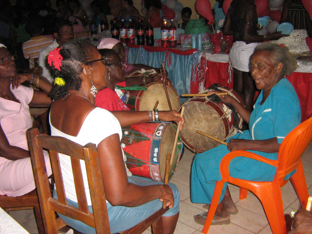 Festejo do Divino no Quilombo Santa Rosa dos Pretos. As Caixeiras cantam e tocam caixa durante o almoço do Império. Severina Pires Belfort que foi eleita Mestra da Cultura em 2013, está entre elas e veste azul.