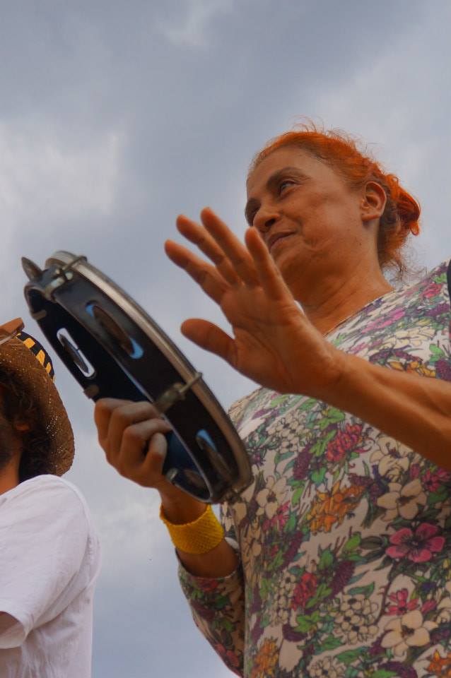 Marise cantando e tocando pandeiro em cortejo de Cosme e Damião na Vila de São Jorge. 2013