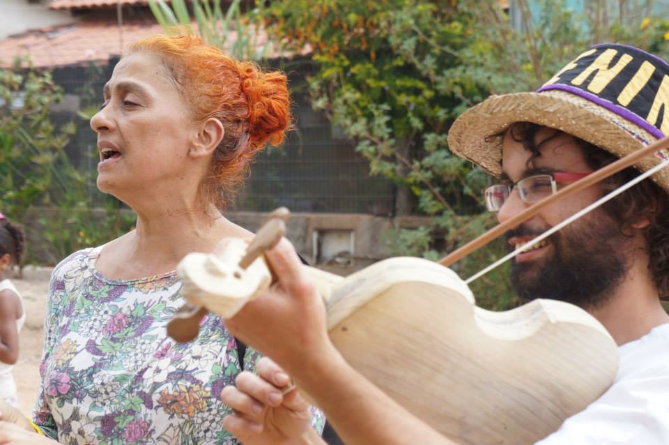 Marise Barbosa cantando e tocando pandeiro e Flavio Teixeira tocando rabeca em cortejo de Cosme e Damião na Vila de São Jorge. 2013