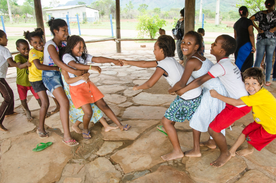 Dois grupos de crianças brincam de cabo de guerra durante o tempo do recreio. Estão no pátio da Escola Tia Desuíta no Território quilombola Kalunga Diadema.